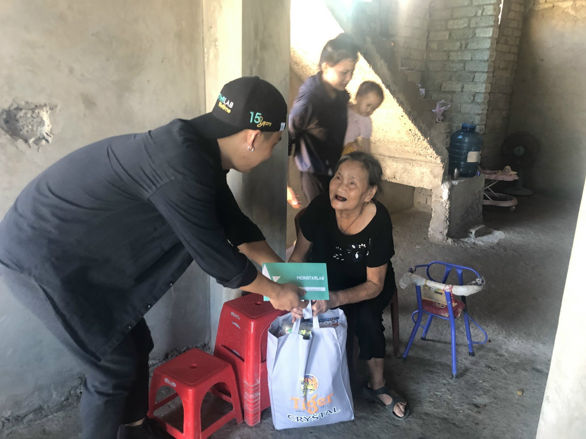 Monstarlab employee hands over the aid to the person rescued from typhoon damage